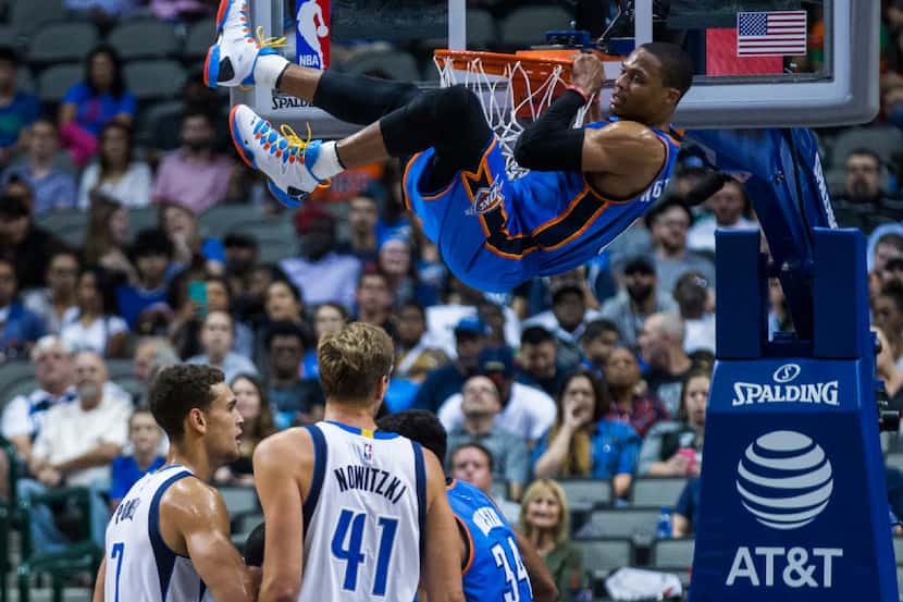 Oklahoma City Thunder guard Russell Westbrook (0) hangs on the basket after a dunk during...