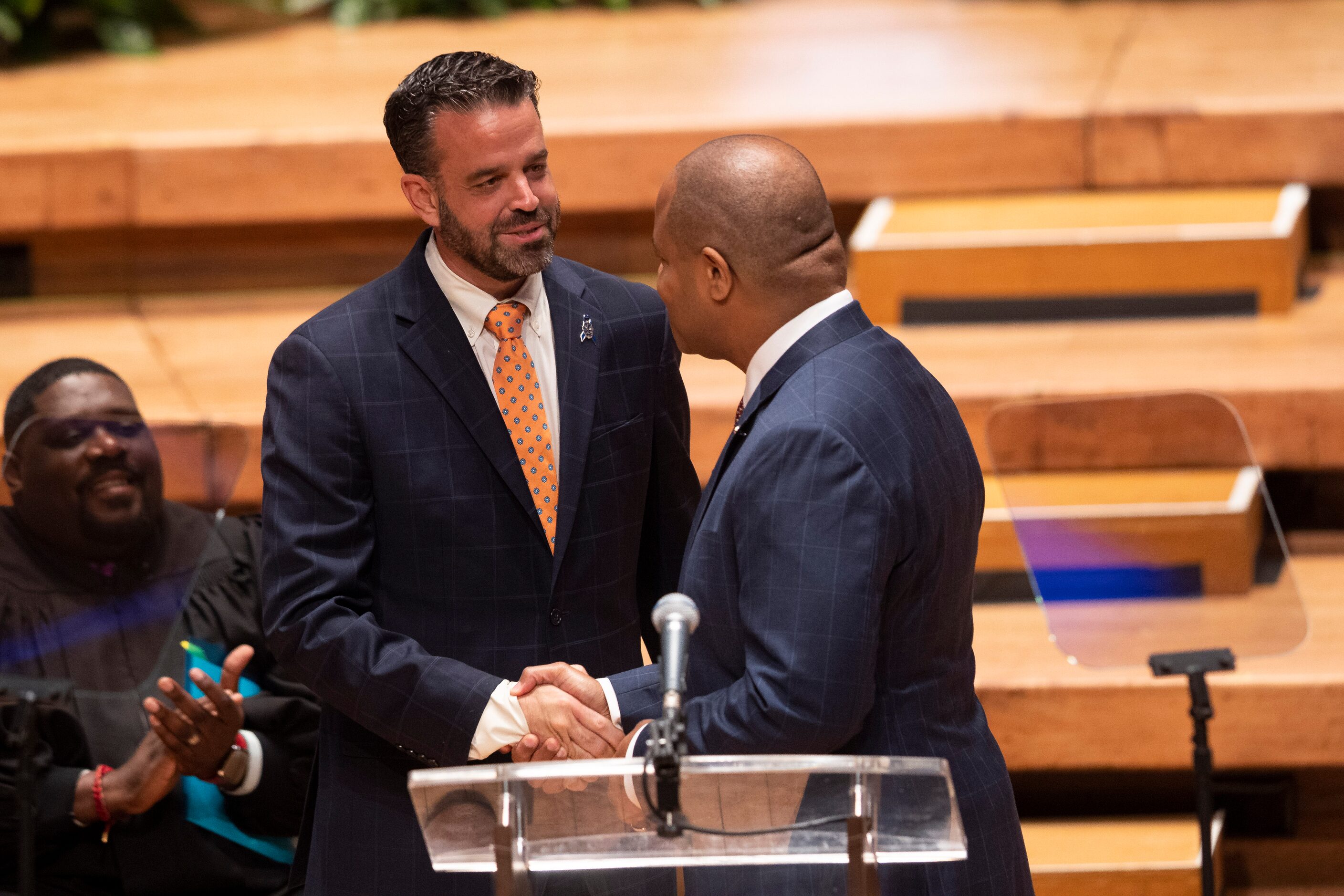 Outgoing city council member Adam McGough shakes hands with Dallas Mayor Eric Johnson while...