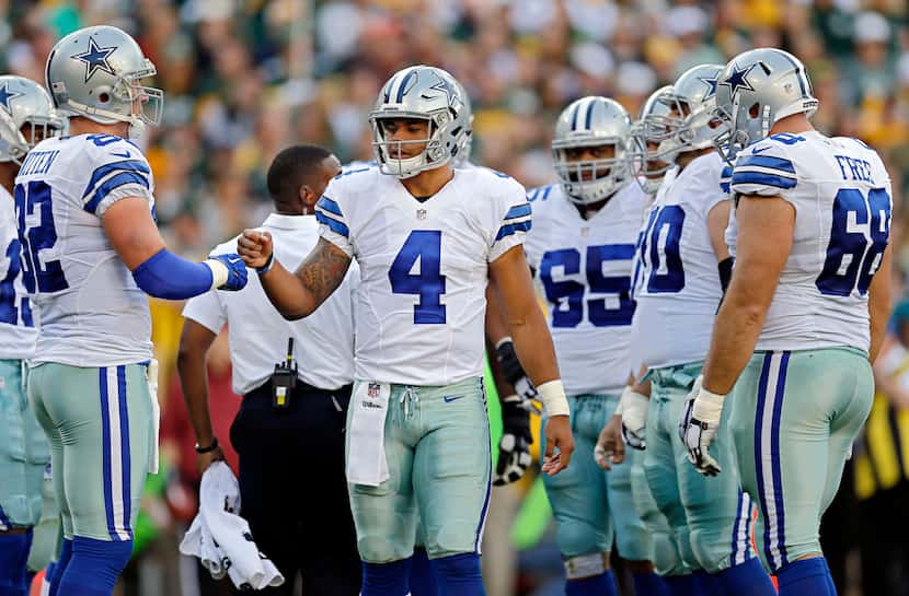 Dallas Cowboys quarterback Dak Prescott (4) fist bumps tight end Jason Witten during a team...