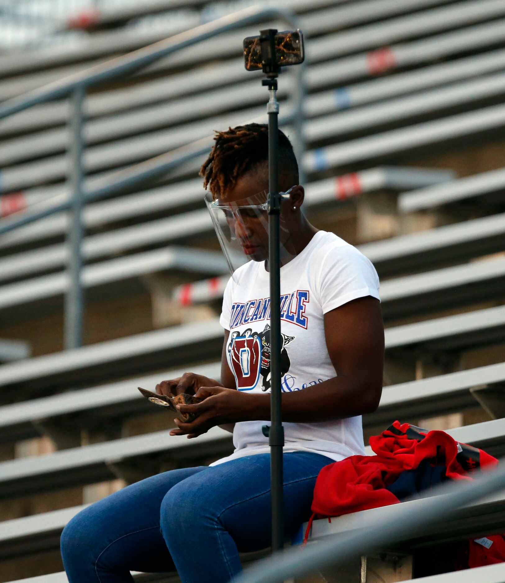 A visor-clad Duncanville fan prepares to make camera video before the start of high school...