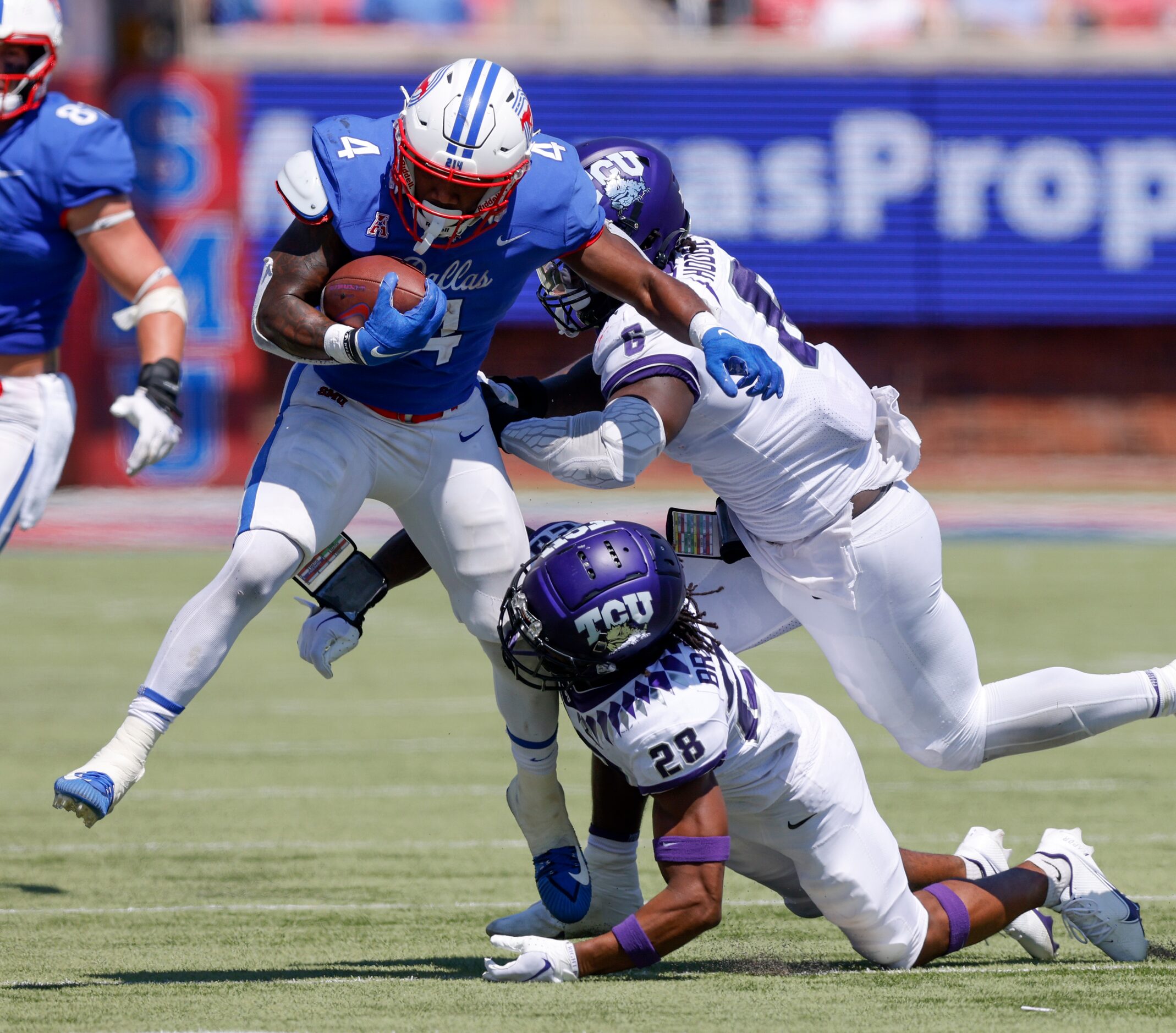 TCU safety Millard Bradford (28) and linebacker Jamoi Hodge (6) tackle SMU running back Tre...