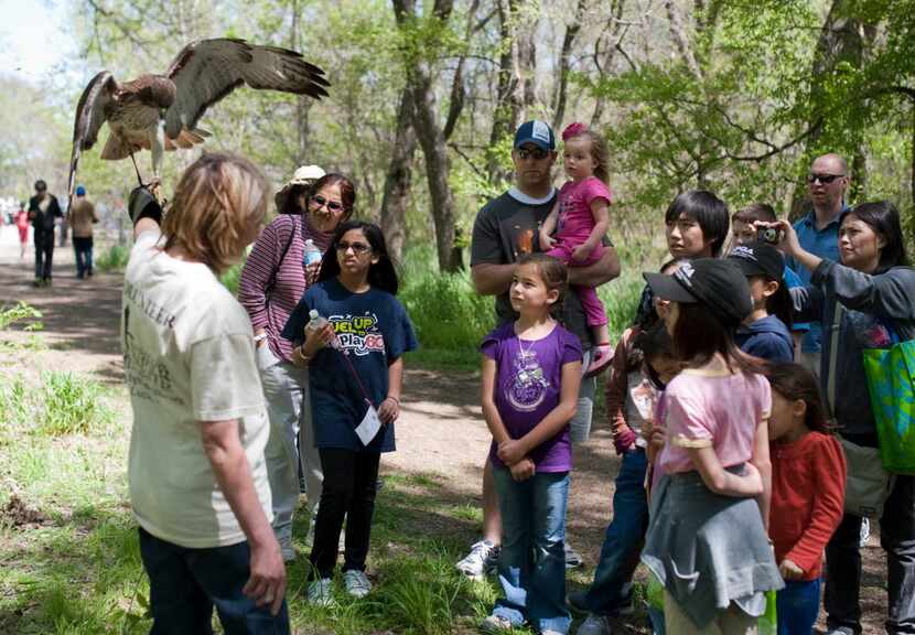 Visitors gather around Kathy Copus of the Blackland Prairie Raptor Center and her red-tailed...