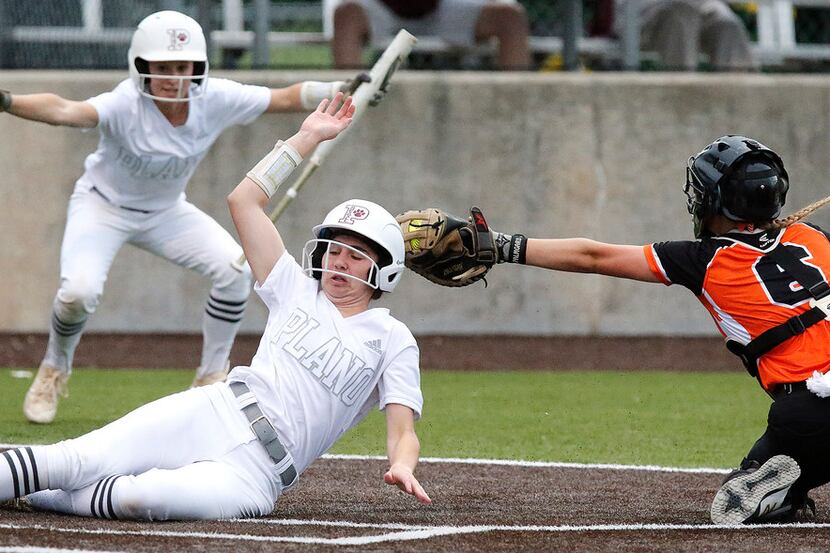 Plano's Maggie Robbins (8) is called safe at home by teammate Cate Bade (1) as Rockwall...