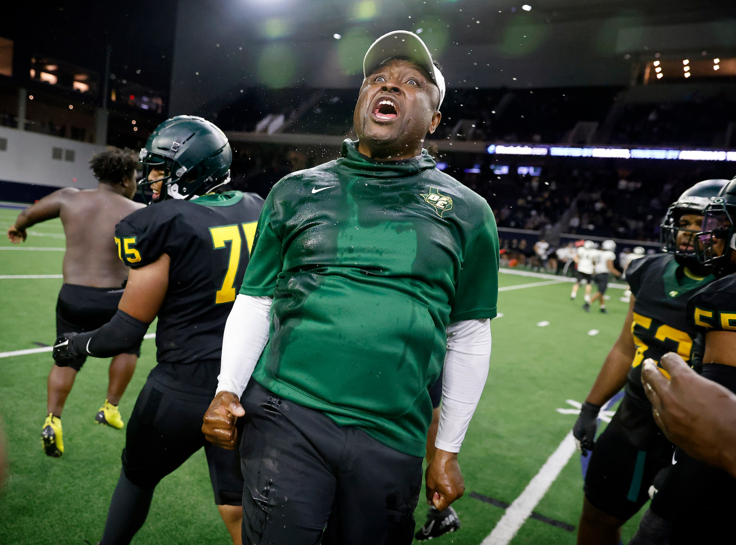 DeSoto head coach Claude Mathis and his players celebrate their Class 6A Division II state...