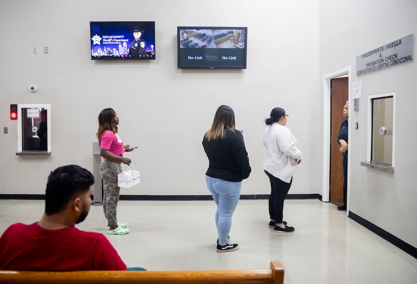 A bond hearing is live-streamed as people talk in the lobby of the Lew Sterrett Justice...