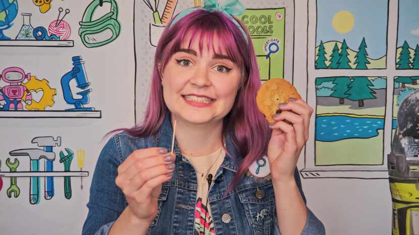 Myria Perez shows kids how to remove a chocolate chip "fossil" from a cookie "rock" in her...