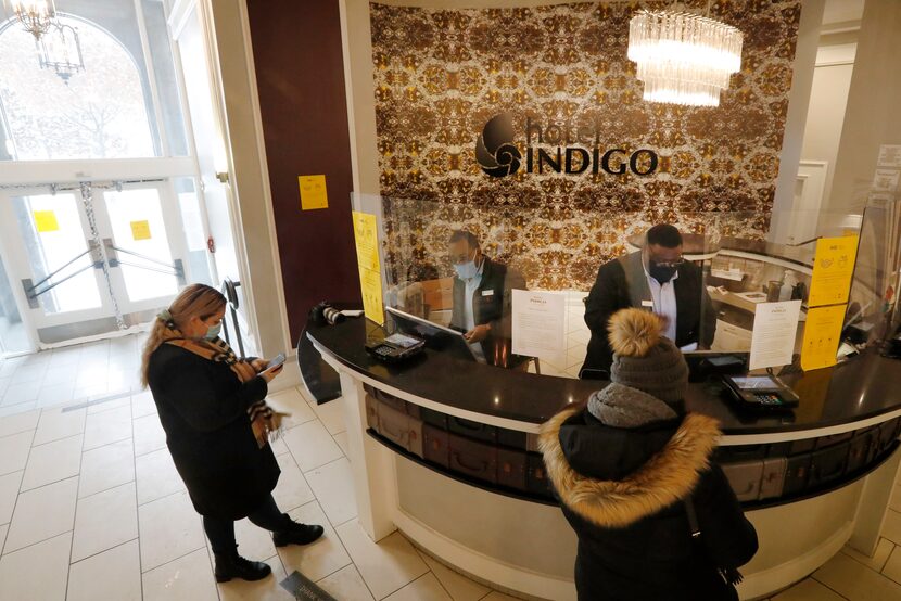 Veronica Quiroz (left) of Seagoville checked her phone as she was being checked in by...