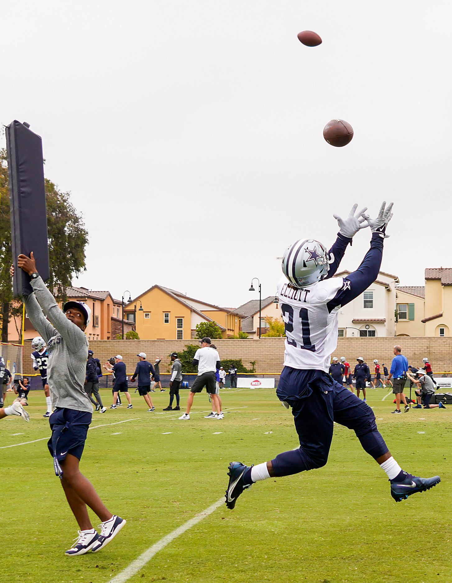 Dallas Cowboys running back Ezekiel Elliott (21) reaches for a ball during a drill at...