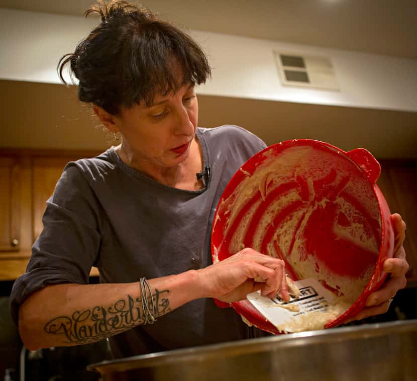 Katherine Clapner scrapes dough from a mixing bowl as she makes kolaches at her home Friday,...