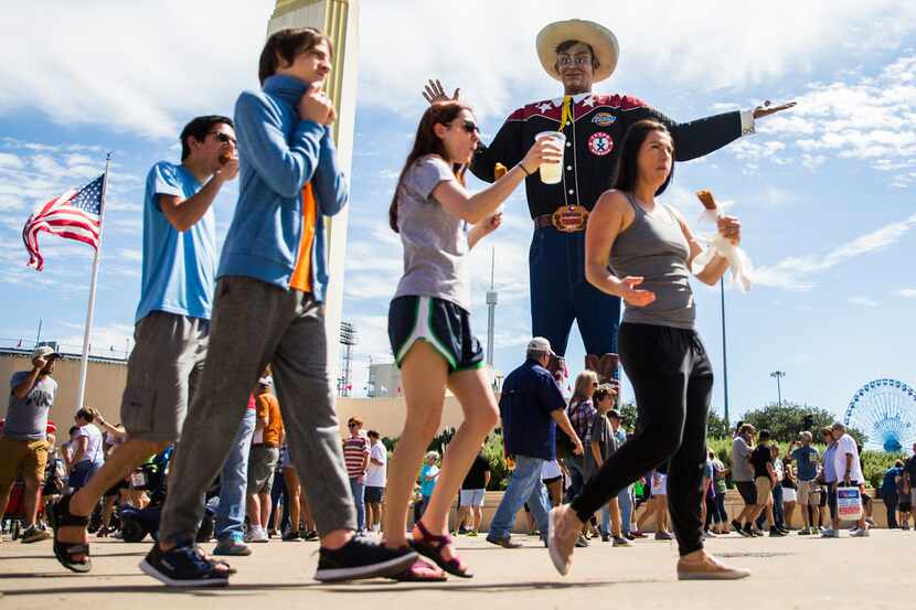 People walk past Big Tex at the State Fair of Texas on Saturday, September 30, 2017 at Fair...