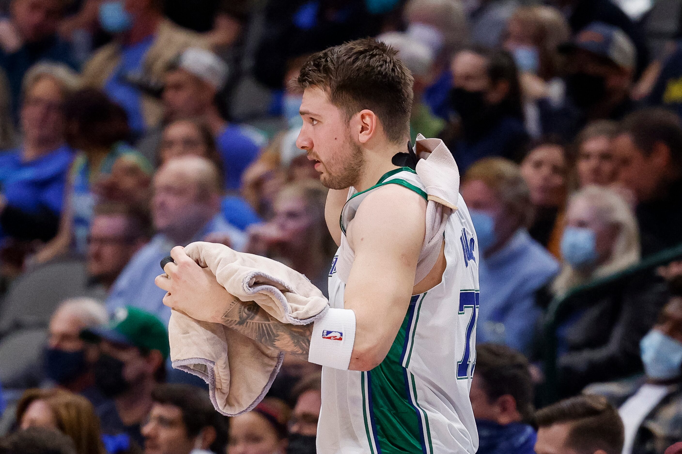 Dallas Mavericks guard Luka Doncic (77) removes a heat pack before entering the game during...