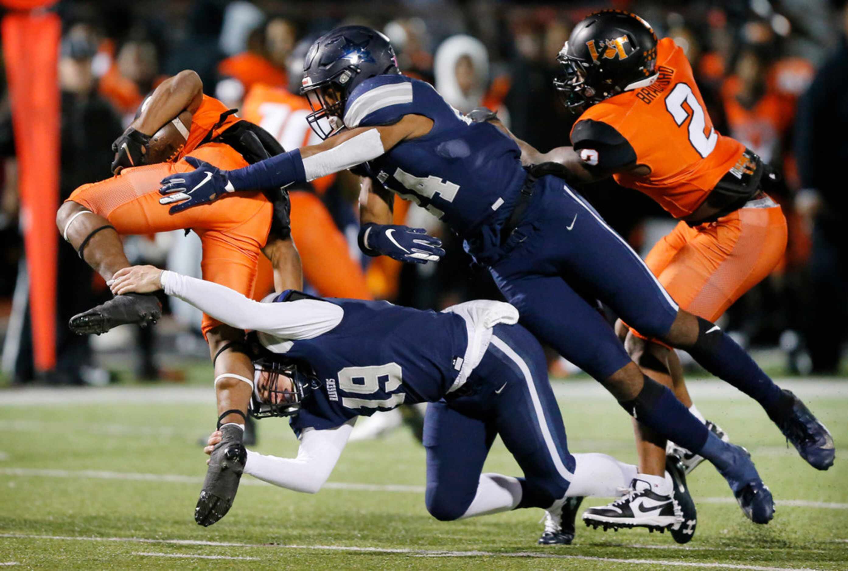 Frisco Lone Star linebackers Landon Whitley (19) and Jaylan Ford (24) bring down Lancaster...