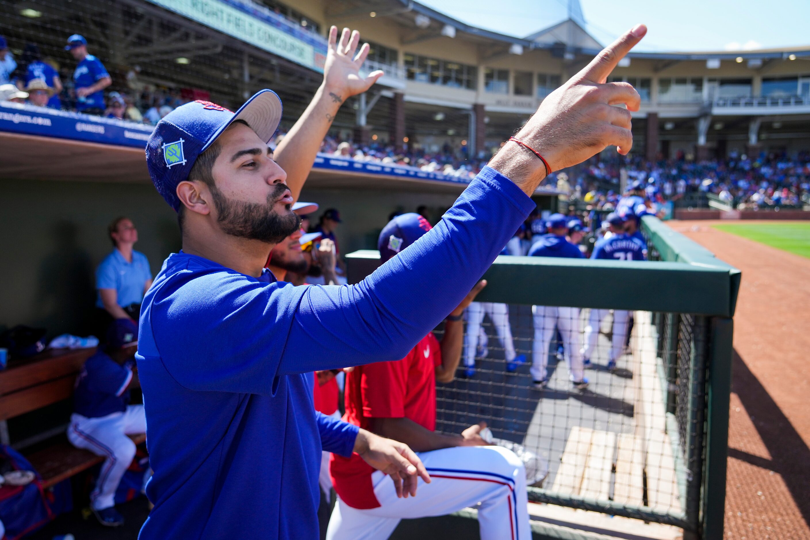 Texas Rangers pitcher Martín Pérez yells toward a Los Angeles Dodgers player from the dugout...