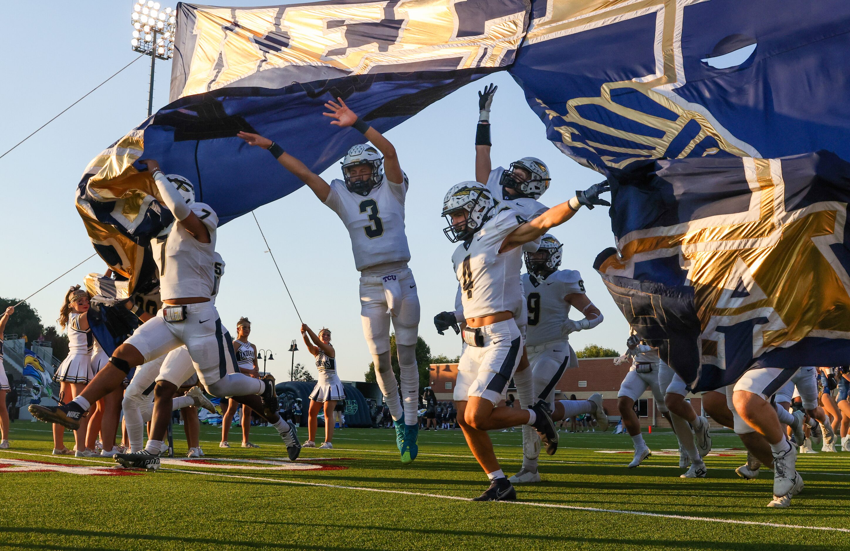 Keller High School players run across the field before their game against V.R. Eaton High...