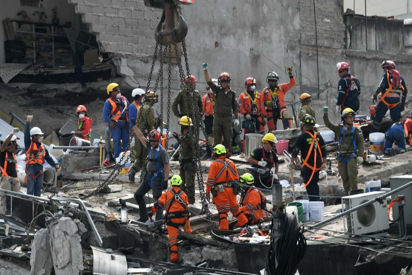 Rescue workers ask for silence during the search of survivors in a building at Colonia Roma...