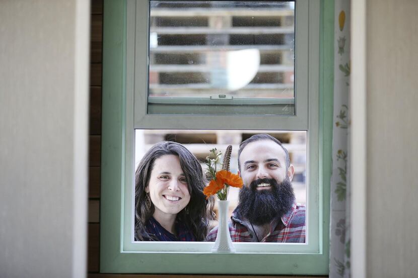 Randi Hennigan and her husband, Cody Hennigan, stand for a portrait outside their tiny...