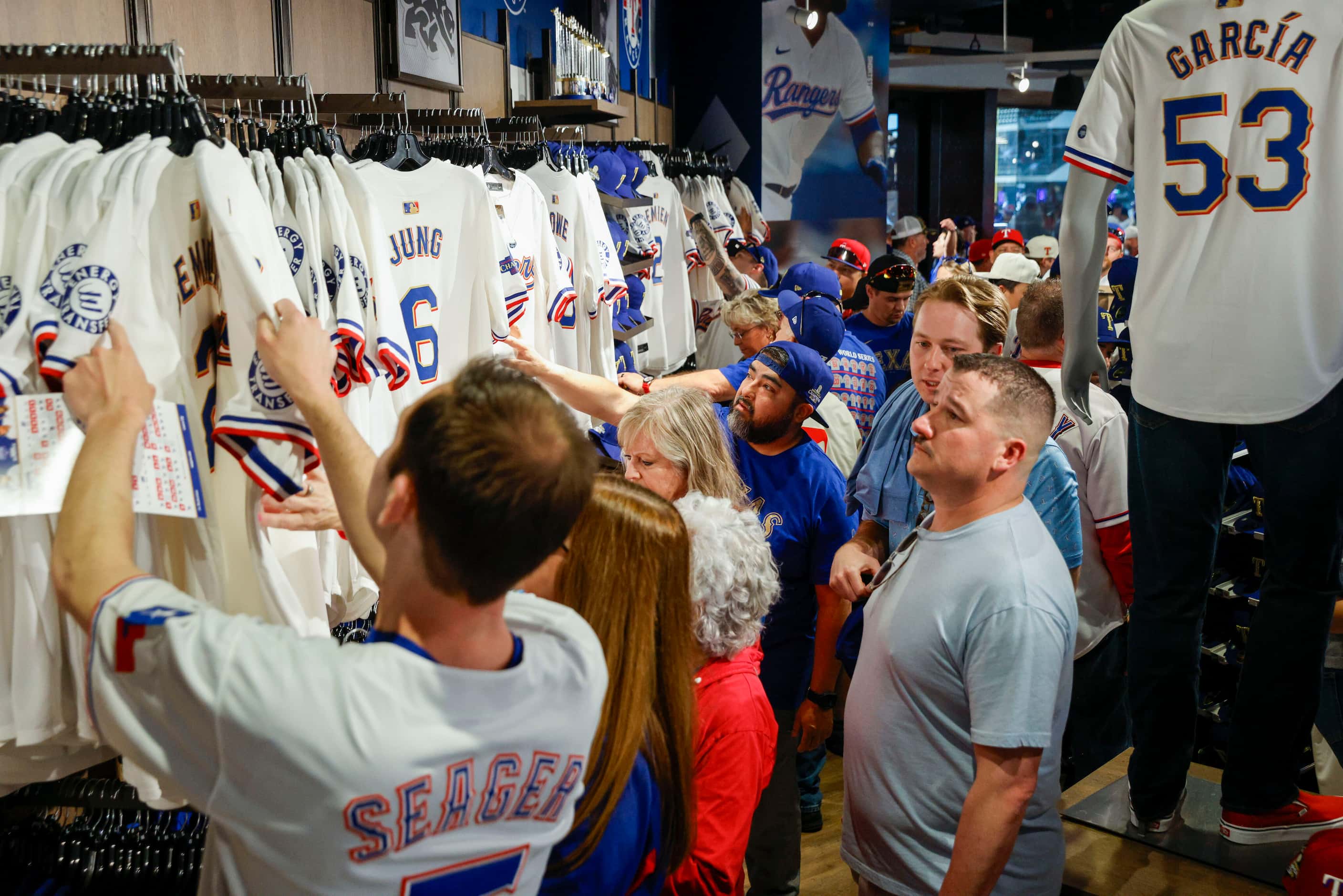 Fans shop for gold-trimmed Texas Rangers jerseys at the team store before the season opener...