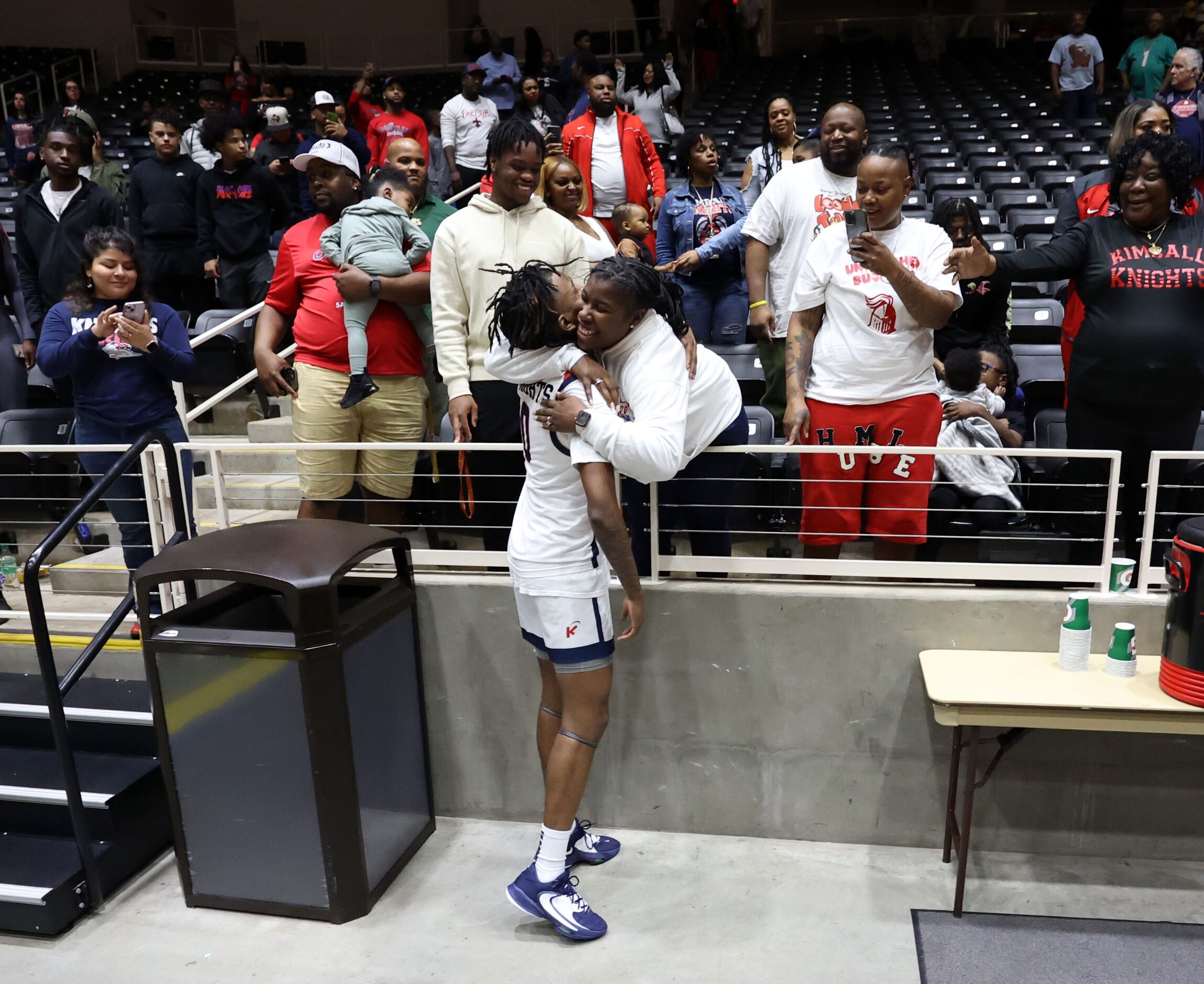 Kimball High’s R.J. Osborne (0) gets a hug after the team’s 63-54 win in the Class 5A State...