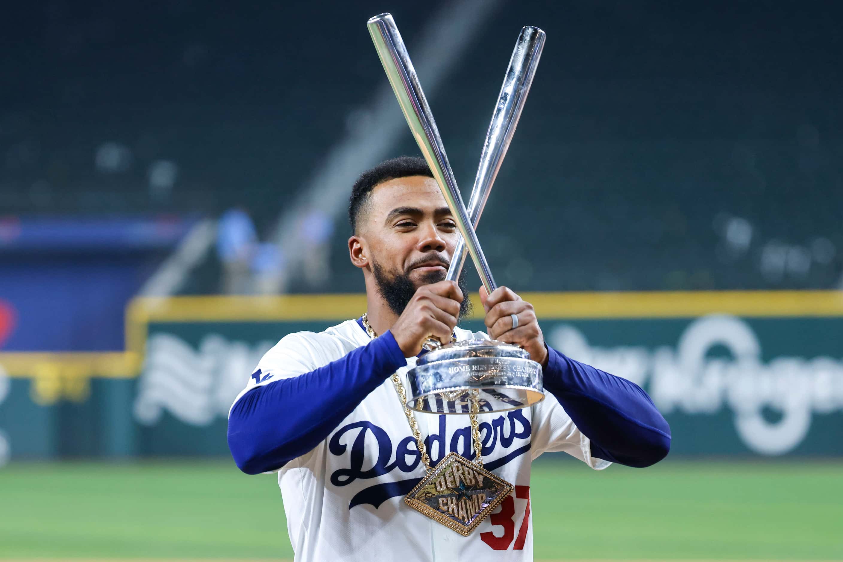 Teoscar Hernández of the Los Angeles Dodgers hoists the winning trophy after defeating...