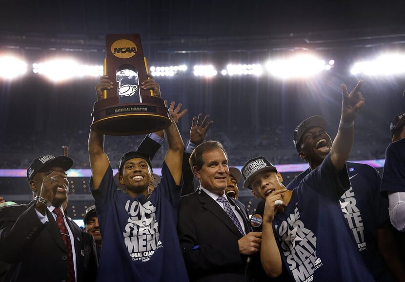 UConn guard Ryan Boatright (11) raises the championship trophy as teammate Shabazz Napier...