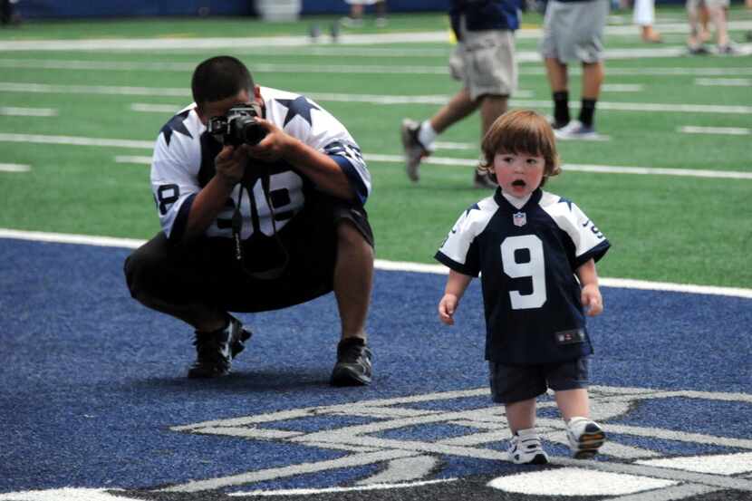 Gabriel Ortiz takes photos of his son playing in the end zone at AT&T Stadium during a Rally...