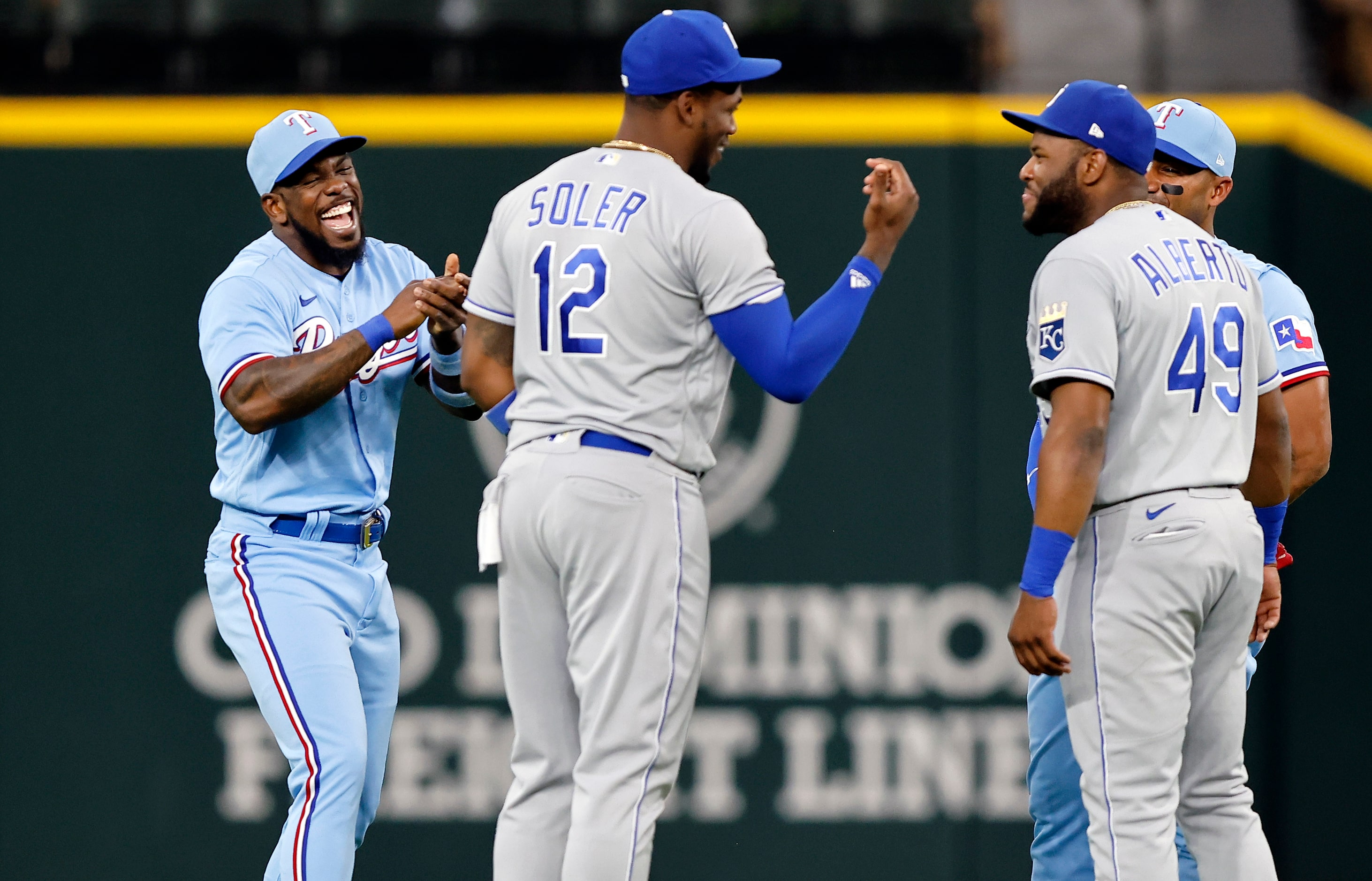 Texas Rangers Adolis Garcia (left) laughs at Kansas City Royals Hanser Alberto (49)  as they...