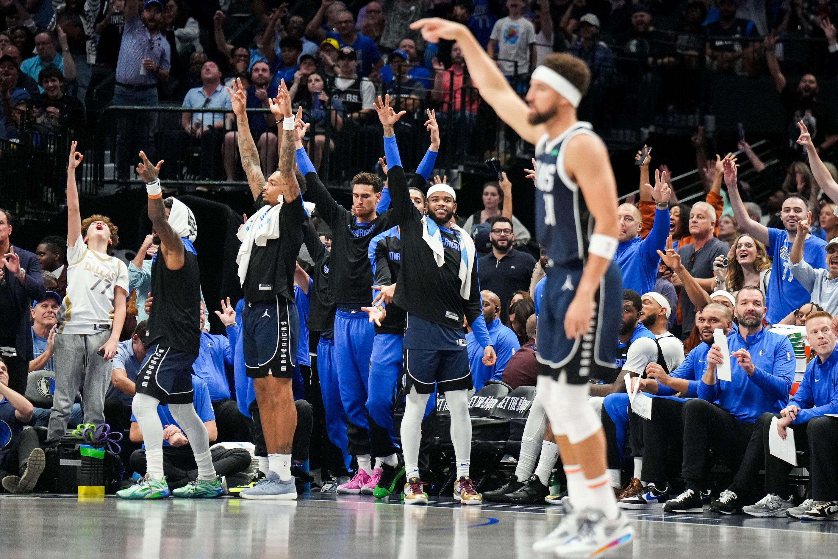 The Dallas Mavericks bench and fans celebrate a 3-pointer by guard Klay Thompson during the...