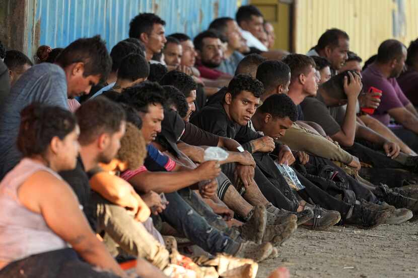 Migrantes que cruzaron el Río Grande y entraron en Estados Unidos esperan ser procesados por...