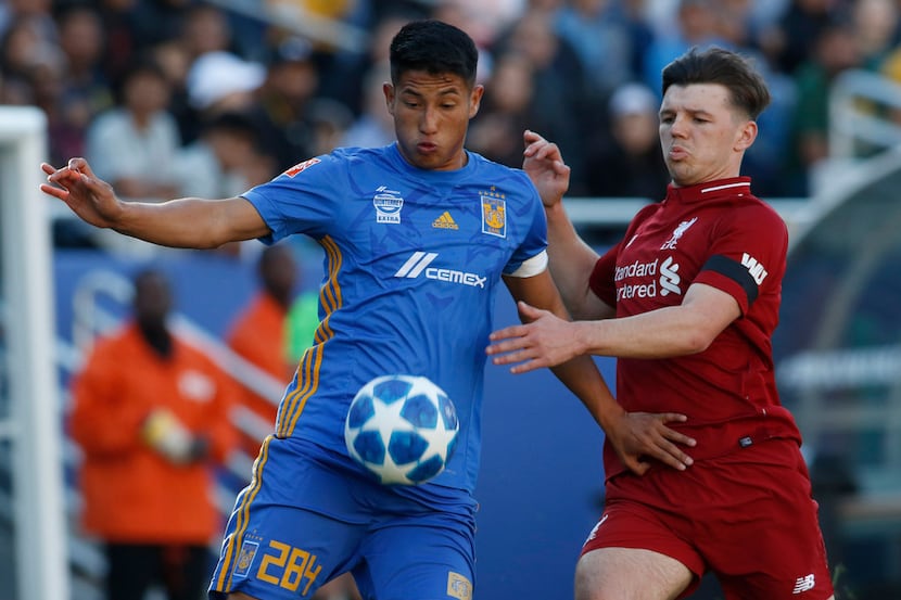 Tigres UANL's Aldo Mota (284) eyes the ball as he is challenged by Liverpool FC's Bobby...