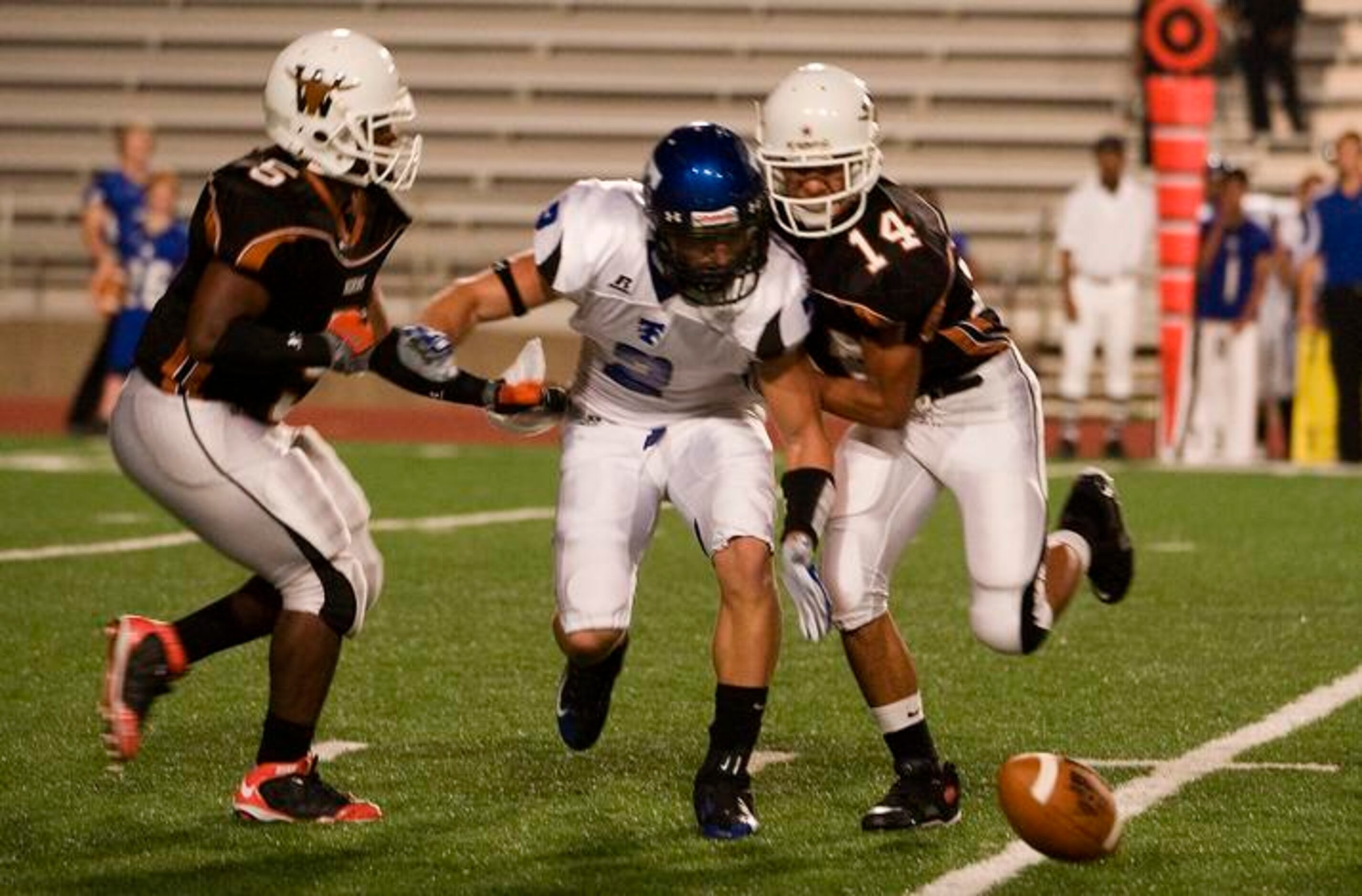 Carrollton R.L. Turner senior wide receiver Cody Mason (center) can't come up with a catch...