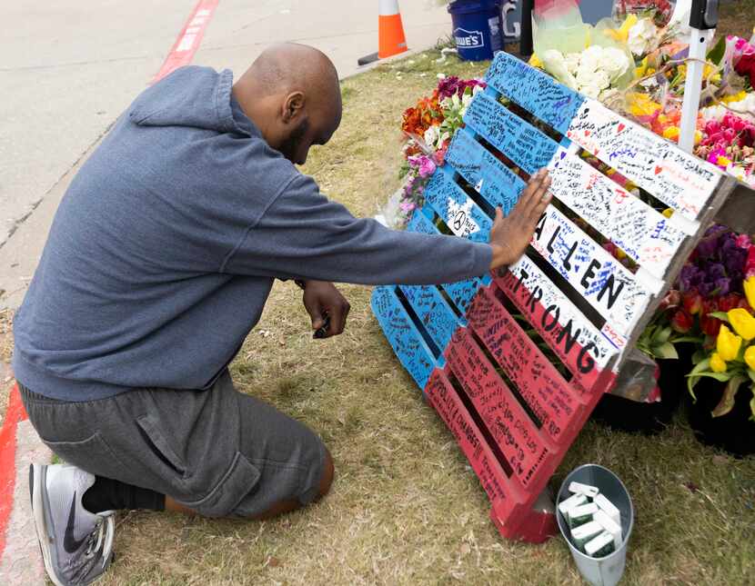 Jay Lewis of Allen prays Friday at the memorial honoring the victims of the mass shooting at...