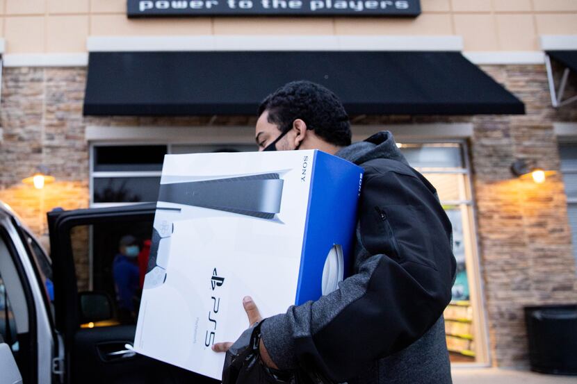 Brandon Lopez of Irving loads his new Playstation 5 in his car after waiting in line since...