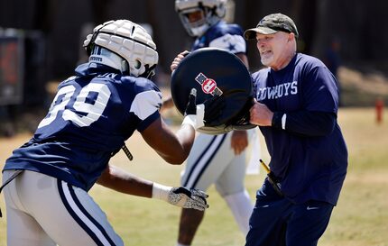 Dallas Cowboys defensive coordinator Dan Quinn winces as defensive end Chauncey Golston (99)...