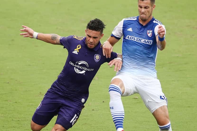 Orlando City's Dom Dwyer, left, and FC Dallas' Matt Hedges battle for the ball at Orlando...