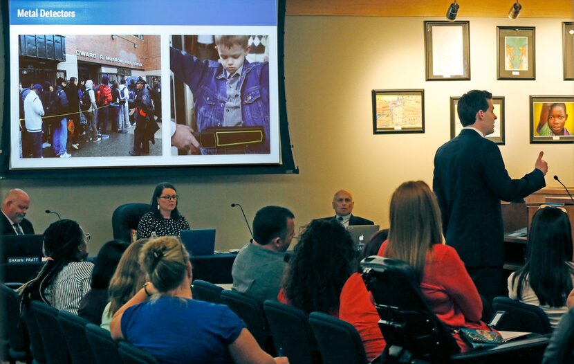 McKinney ISD spokesman Cody Cunningham talks with the school board about putting metal...