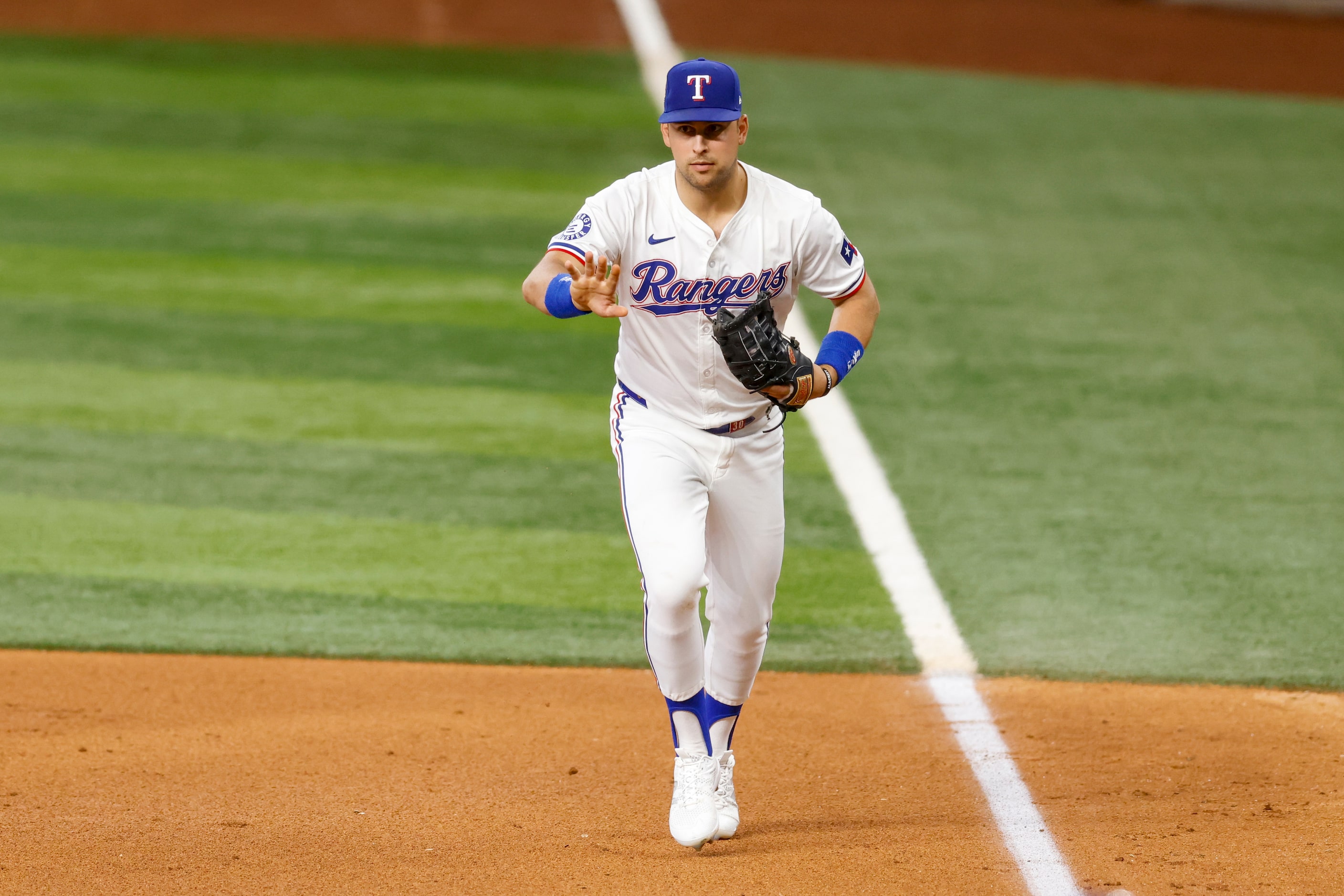 Texas Rangers first baseman Nathaniel Lowe (30) fields a ground ball from Kansas City Royals...