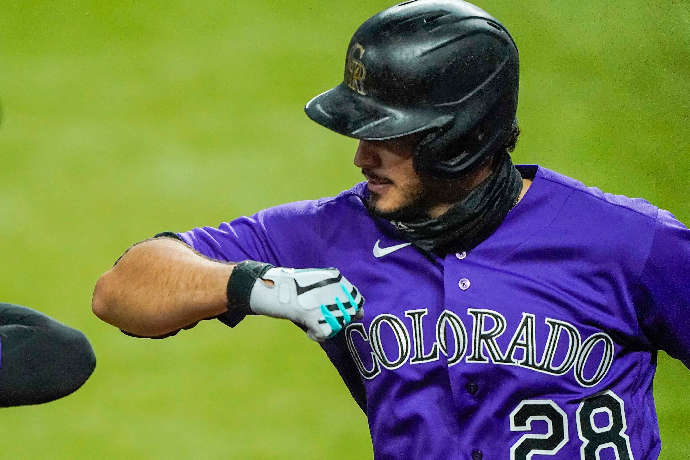 Colorado Rockies third baseman Nolan Arenado elbow bumps with second baseman Ryan McMahon...