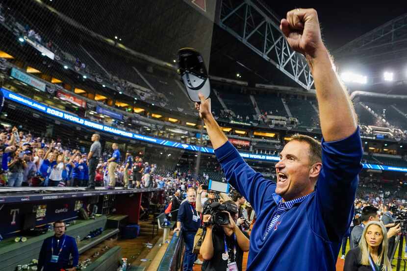 Texas Rangers general manager Chris Young yells to fans as Rangers players celebrate after...