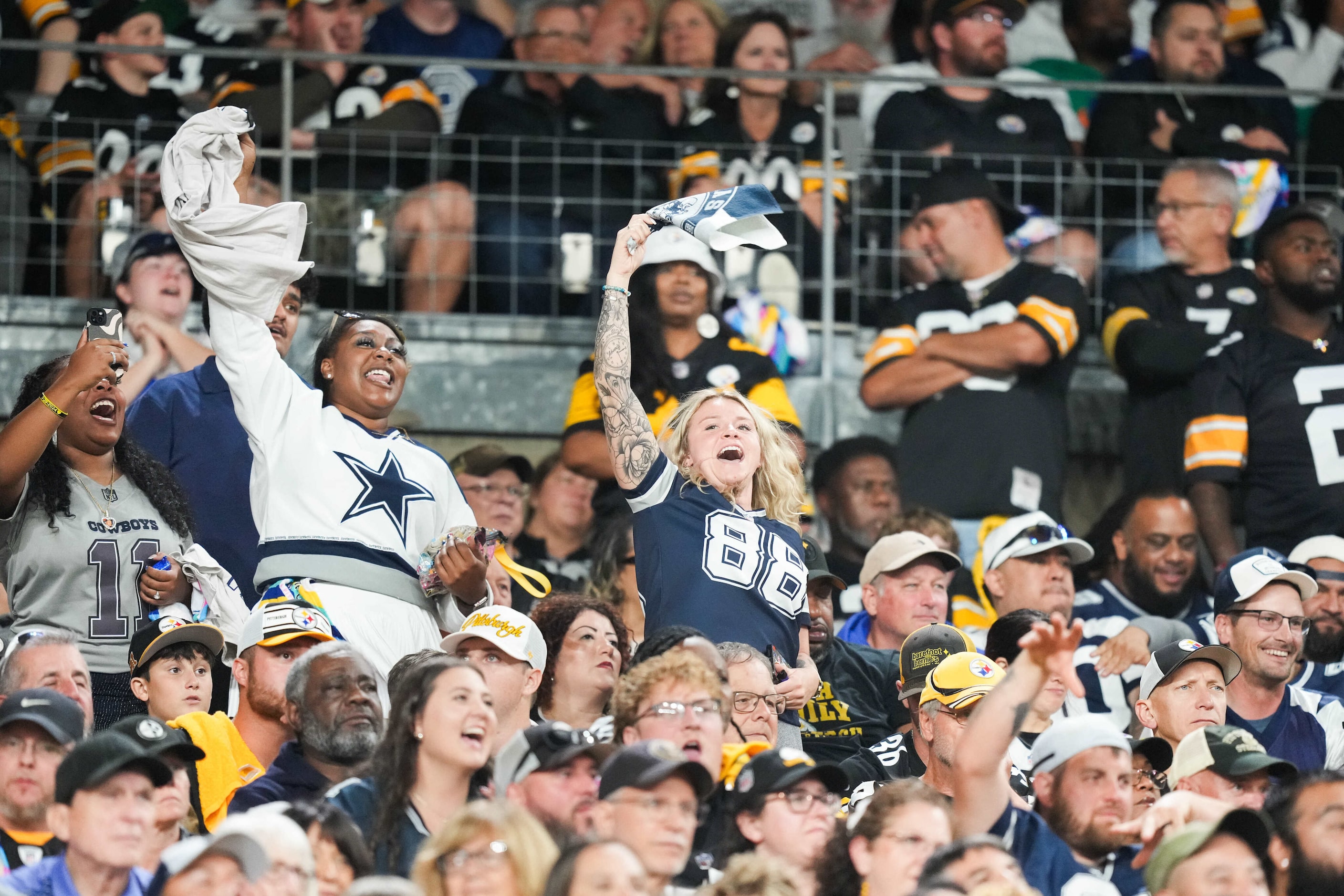 Dallas Cowboys fan cheer their team during the second half of an NFL football game against...