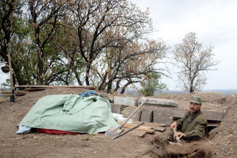 
A pro-Russian fighter dug in Thursday in Troitsko-Khartsyzk, 19 miles east of Donetsk....