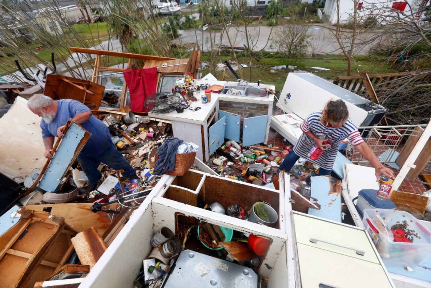 Bill and Paulette Rogers search for his wallet after Hurricane Harvey destroyed their house...