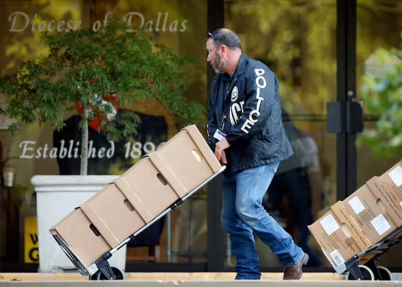 Dallas police cart out boxes from a raid on the Catholic Diocese of Dallas on Wednesday....