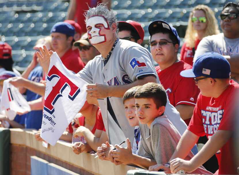 Rangers fan William DeLapaz waits with other fans for autographs during batting practice....