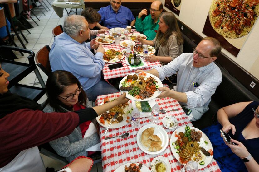 John Allums grabs a plate of Iraqi food during the 'Breaking Bread' cultural exchange dining...