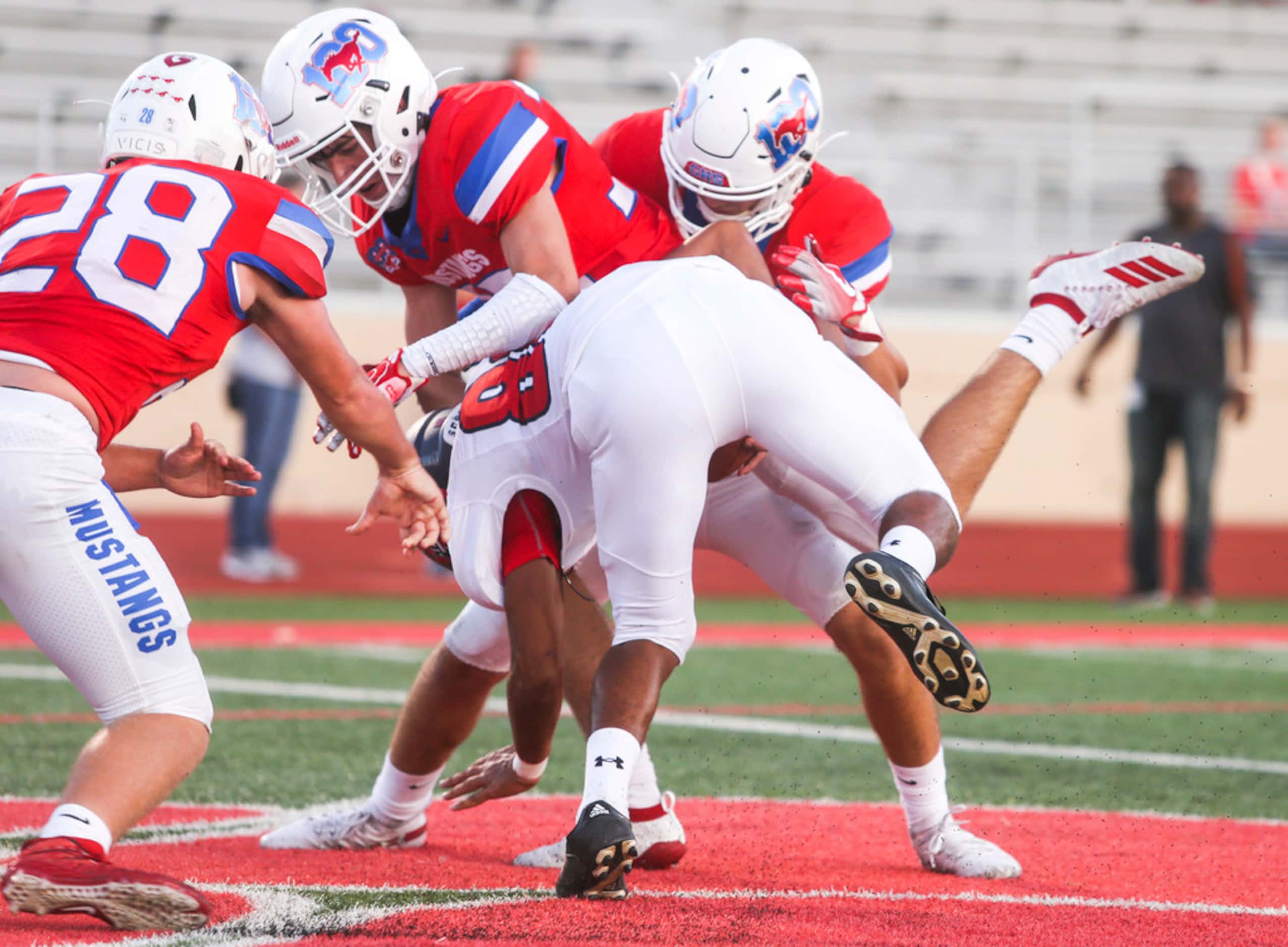 Grapevine players wrap up Daniel Lopez in the end zone for a safety during the first half of...