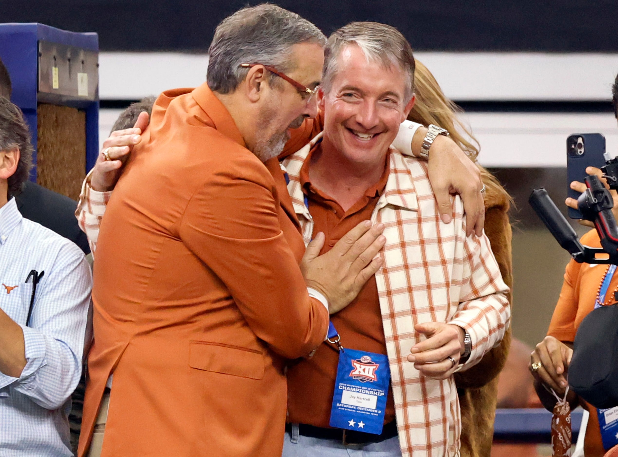 University of Texas Athletic Director Chris Del Conte (left) hugs President Jay Hartzell as...