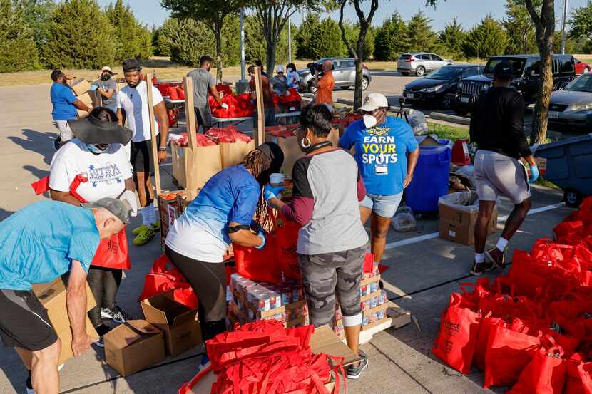 Volunteers prepare bags of food before a North Texas Food Bank mobile food pantry...
