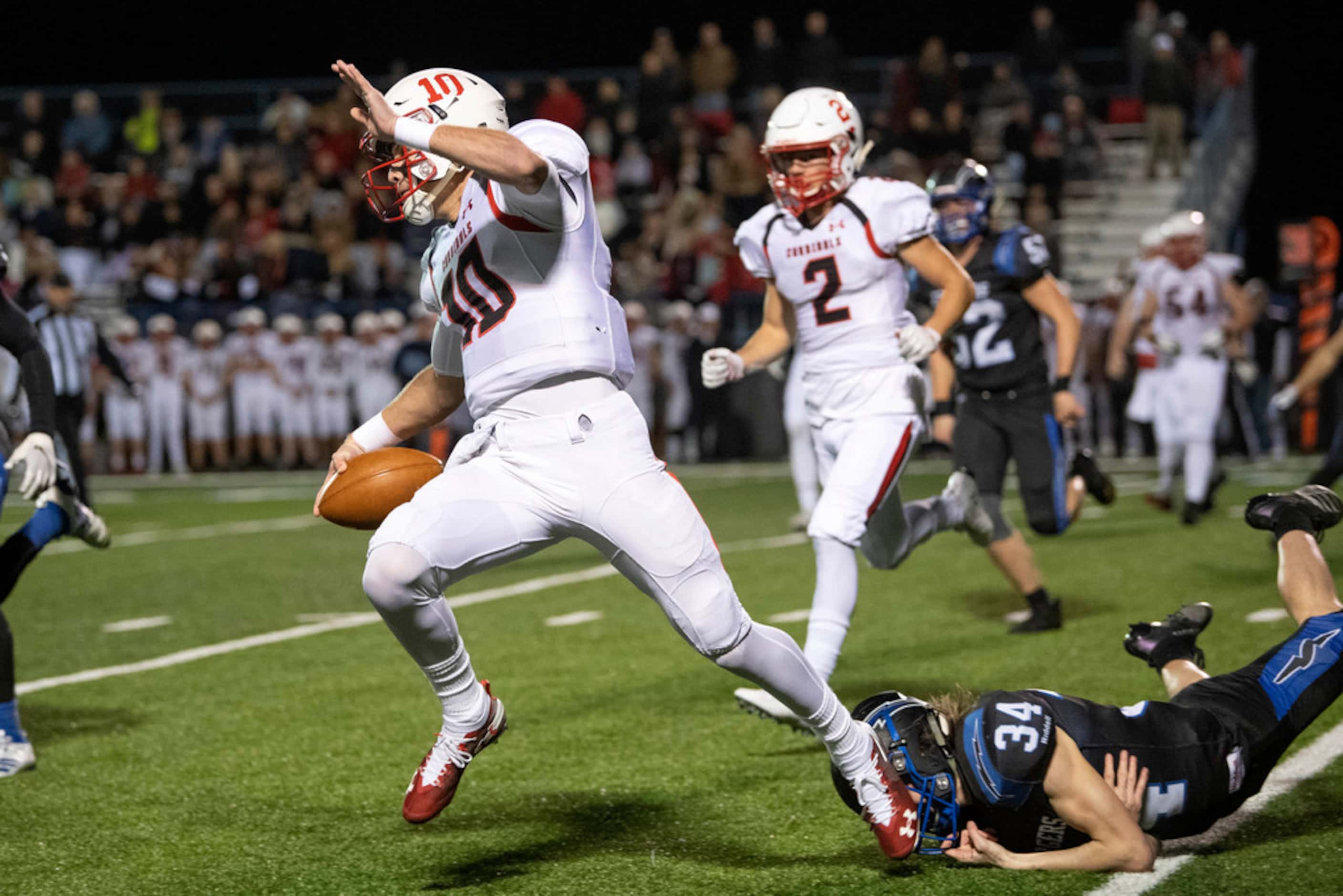 Fort Worth Christian senior quarterback Carson Cross (10) escapes the attempted tackle of...