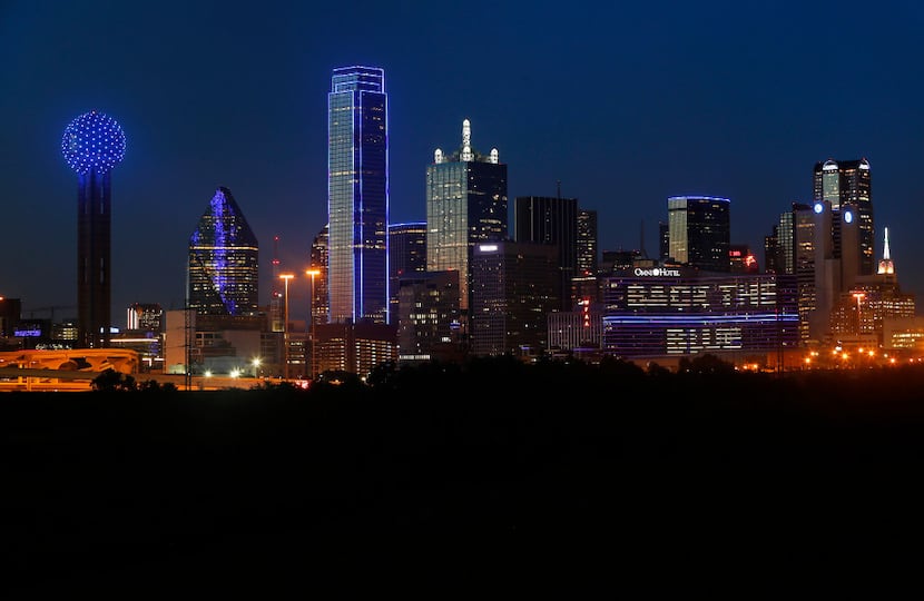 The skyline of Dallas is aglow in blue on July 7, 2017 to remember the four Dallas police...