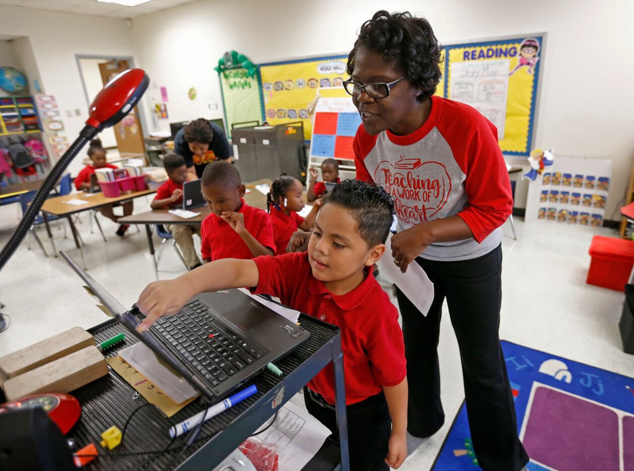 Teacher Vondella Rogers  helps kindergartner Adrian Flores with a sequencing drag and drop...